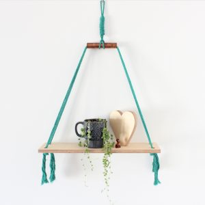Teal cotton macrame cord and birch plywood shelves with copper accent styled with a hand cut birch plywood heart shelfie and a string of pearls succulent in a navy vintage mug