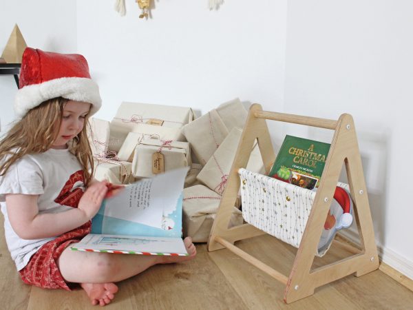 Girl reading in front of a white book caddy with gold and silver stars