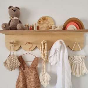 Scalloped peg shelf with neutral toned handmade nursery decor pieces
