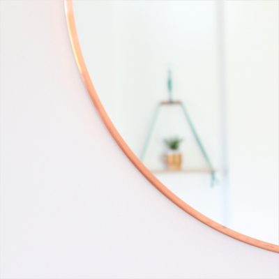 copper mirror with jade macrame shelf burred out in the reflection